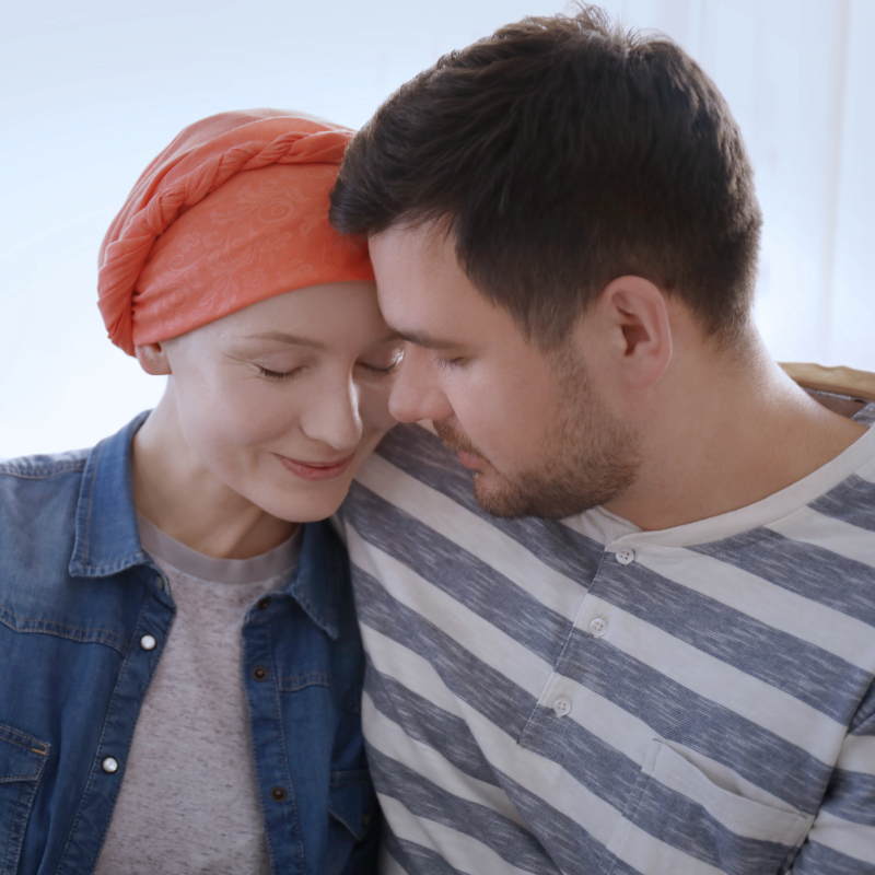 A couple sharing a tender moment - a woman wearing a headscarf leaning close to her partner